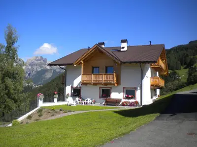 a house on a hill with mountains in the background at Prensanueva in Santa Cristina in Val Gardena