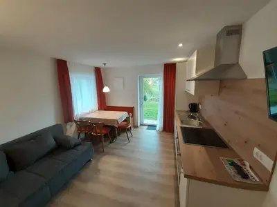 a kitchen and a living room with a couch and a table at Prensanueva in Santa Cristina in Val Gardena