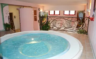 a jacuzzi tub in a room with a mosaic wall at Hotel La Montanina in Alleghe