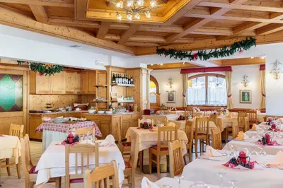 a dining room with white tables and chairs at Hotel La Montanina in Alleghe