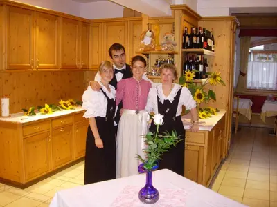 a group of people standing in a kitchen at Hotel La Montanina in Alleghe