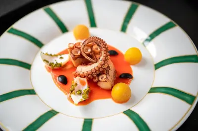 a white plate with food on a table at Castel Hörtenberg in Bolzano