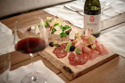 a table with a bottle of wine and a plate of food at Castel Hörtenberg in Bolzano