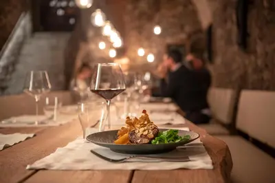 a plate of food on a table with wine glasses at Castel Hörtenberg in Bolzano