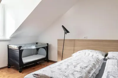 a bedroom with a bed and a chair at Apartment Villa Schmid in Bolzano