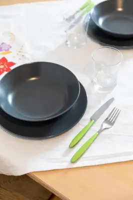 a black plate and fork and knife on a table at Apartment Villa Schmid in Bolzano
