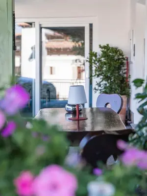 a small lamp sitting on a table with flowers at Pension Chalet Andy in Schenna