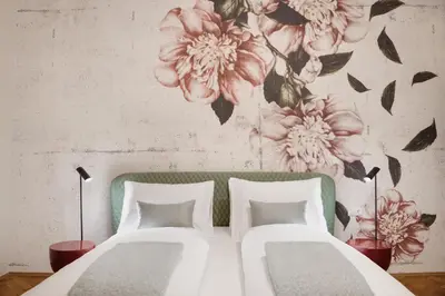 a bedroom with a bed with a floral wall mural at Arte Apartments in Bolzano