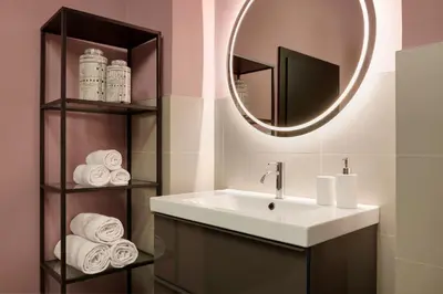 a bathroom with a sink and a mirror and towels at Arte Apartments in Bolzano