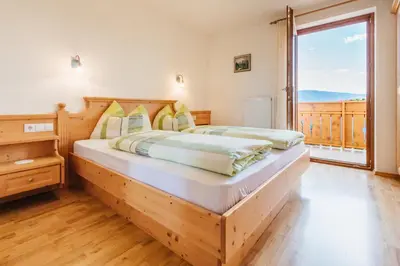 a bedroom with a wooden bed and a large window at Residence Speckerhof in Maranza