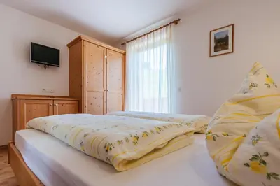 a bedroom with a bed and a tv on a wall at Residence Speckerhof in Maranza