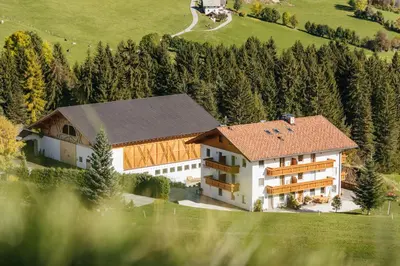 a large building with a brown roof on a hill at Residence Speckerhof in Maranza
