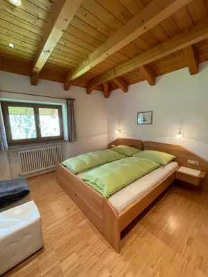 a bedroom with a large bed in a room with wooden ceilings at Feldererhof in Postal