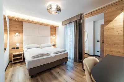 a bedroom with a large bed and a desk at Cesa Planber Apartments Mountain View SKI-IN SKI-OUT in Canazei