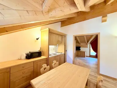 a kitchen with wooden cabinets and a wooden table at Cesa Planber Apartments Mountain View SKI-IN SKI-OUT in Canazei