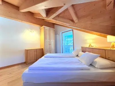 two beds in a room with wooden ceilings at Cesa Planber Apartments Mountain View SKI-IN SKI-OUT in Canazei