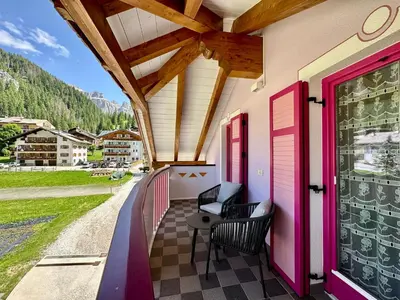 a porch with chairs and a view of a mountain at Cesa Planber Apartments Mountain View SKI-IN SKI-OUT in Canazei