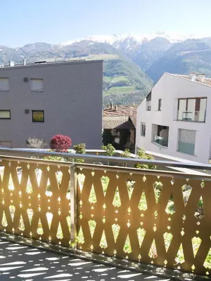 a yellow fence on a balcony with mountains in the background at Appartement Baumgärtner in Naturno