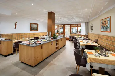 a dining room with tables and chairs in a restaurant at Garni-Hotel Tritscherhof in Tirolo