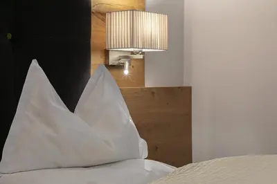 a white pillow sitting on top of a bed at Garni-Hotel Tritscherhof in Tirolo