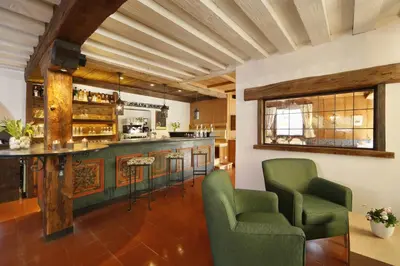 a kitchen with a bar and two chairs in a room at Parkhotel Tirolerhof in Lagundo