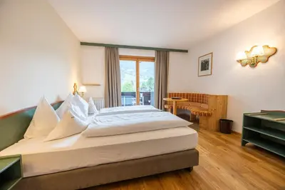 a bedroom with a large bed and a desk at Parkhotel Tirolerhof in Lagundo