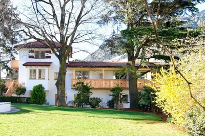 a white house with trees in front of it at Parkhotel Tirolerhof in Lagundo