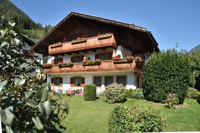 a house with a balcony with flowers on it at Ferienwohnungen Burgwies in San Martino