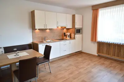 a kitchen and dining room with a table and chairs at Ferienwohnungen Burgwies in San Martino