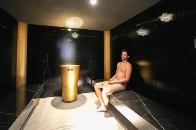 a man sitting on a stage in a dark room at Hotel Pozzamanigoni in Selva di Val Gardena