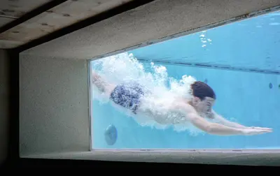 a person swimming in the water in a swimming pool at Hotel Pozzamanigoni in Selva di Val Gardena