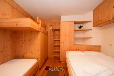 two bunk beds in a room with wooden walls at Apartment Sissi in Badia
