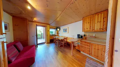 a living room with a red couch and a kitchen at Apartment Sissi in Badia