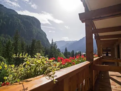 a balcony with a view of flowers and mountains at Hotel Engel in Canazei