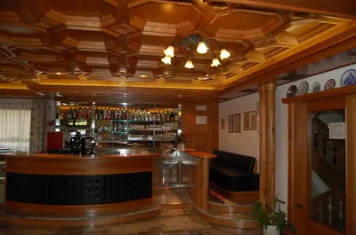 a bar in a pub with a wooden ceiling at Hotel Engel in Canazei
