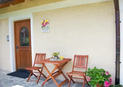 a wooden table and two chairs next to a door at Peterer Hof in Rasùn di Sotto