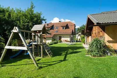 a yard with a swing set and a house at Peterer Hof in Rasùn di Sotto