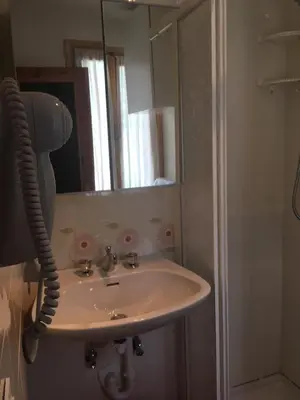 a bathroom with a sink and a mirror at Monolocale DORI in Alleghe