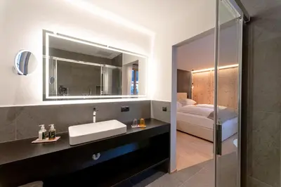 a bathroom with a sink and a mirror at Penserhof - Alpine Hotel & Restaurant in Sarntal