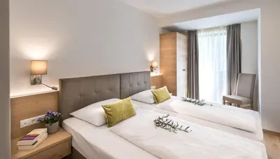 a bedroom with a large white bed in a room at Apartm. & BB Ferienidylle Gstrein in Rablà