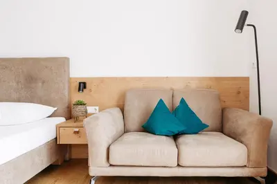a living room with a couch with two blue pillows at Apartm. & BB Ferienidylle Gstrein in Rablà
