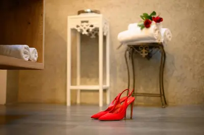 a pair of red heels in front of a mirror at Central Home Apartment in Ortisei