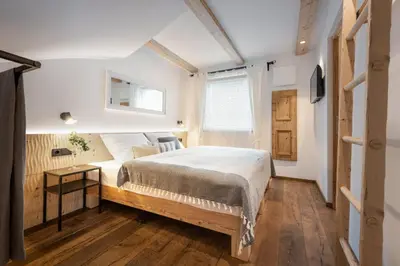 a bedroom with a large bed and a wooden floor at Central Home Apartment in Ortisei