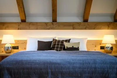 a bedroom with a blue bed with two lamps at Central Home Apartment in Ortisei