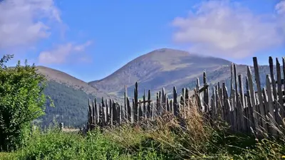 a wooden fence with mountains in the background at Holiday Residence Mesenhaus in Maranza
