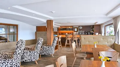 a restaurant with tables and chairs and a bar at Holiday Residence Mesenhaus in Maranza