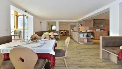 a dining room with a table and chairs and a kitchen at Holiday Residence Mesenhaus in Maranza