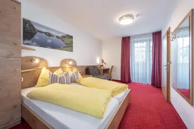 a bedroom with a large bed with yellow sheets at Holiday Residence Mesenhaus in Maranza