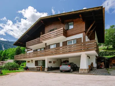 a large log cabin in the snow with a christmas tree at Apartment Mantina-1 by Interhome in Moena