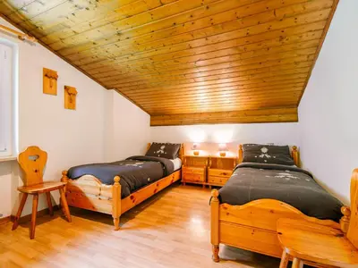 a bedroom with two beds and a wooden ceiling at Apartment Mantina-2 by Interhome in Moena